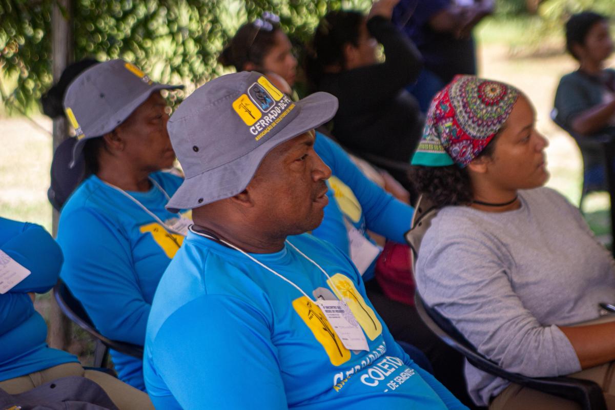 Ni Kalunga aparece em foto sentado, ouvindo uma palestra