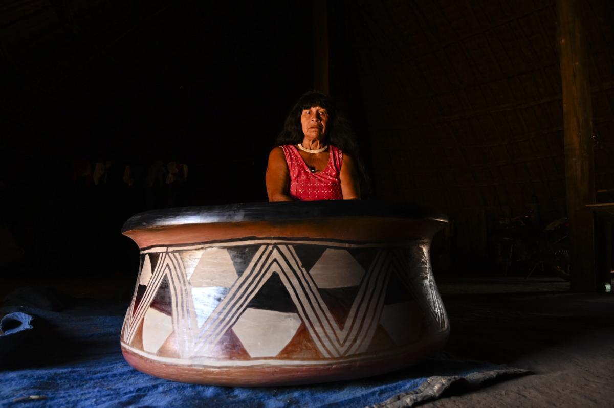 Yakakumalu Waurá com sua panela grande. São necessários três homens para carregar a peça