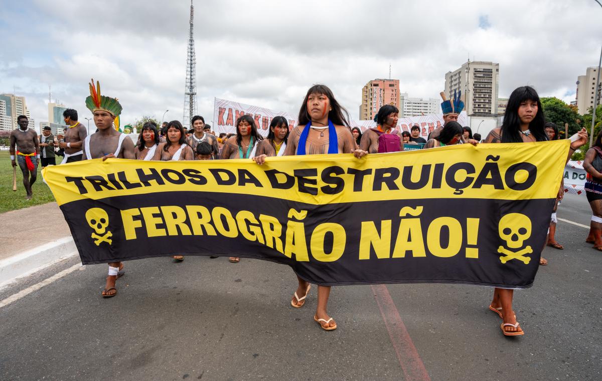 Participantes da marcha do Acampamento Terra Livre com o cartaz "Trilhos da destruição. Ferrogrão não!"